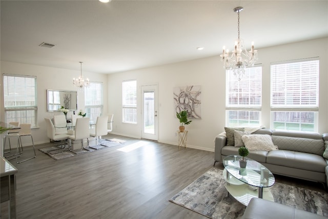 living room with plenty of natural light, hardwood / wood-style floors, and a notable chandelier