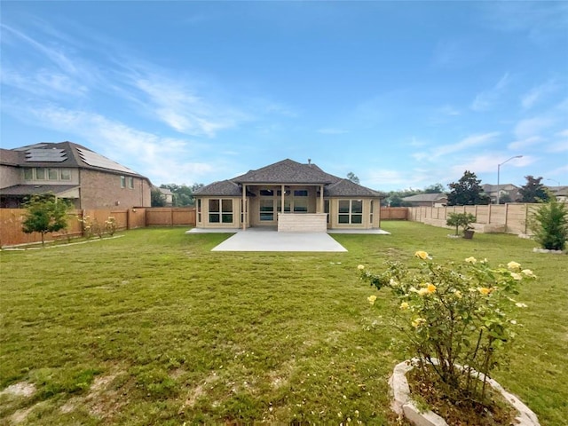 rear view of property featuring a sunroom, a patio area, and a yard