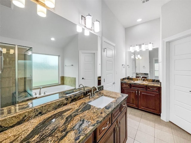 bathroom with tile patterned flooring, vanity, and plus walk in shower