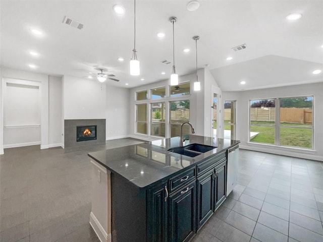 kitchen featuring sink, dishwasher, tile patterned floors, pendant lighting, and a kitchen island with sink