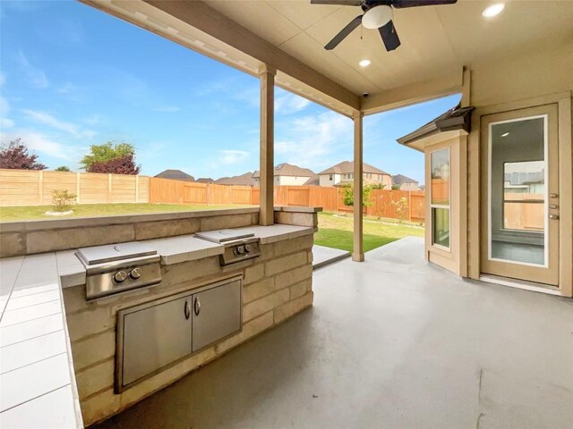 view of patio / terrace featuring ceiling fan and exterior kitchen