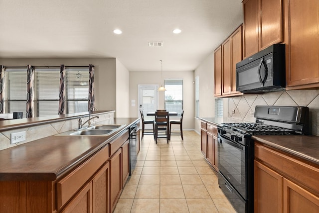 kitchen with black appliances, tasteful backsplash, light tile patterned floors, hanging light fixtures, and sink