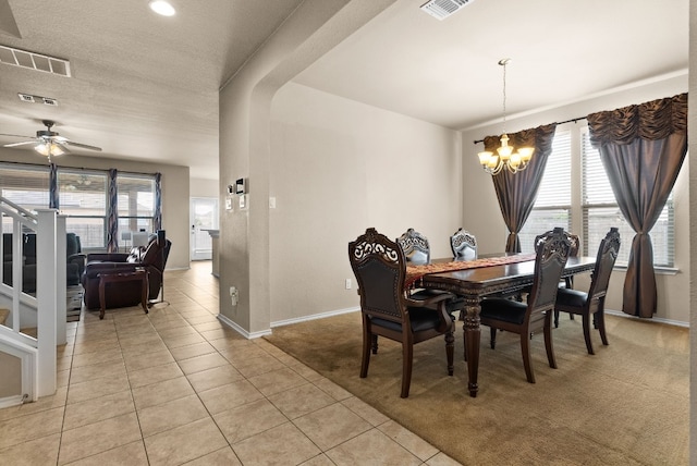 dining room featuring a textured ceiling, ceiling fan with notable chandelier, and light carpet