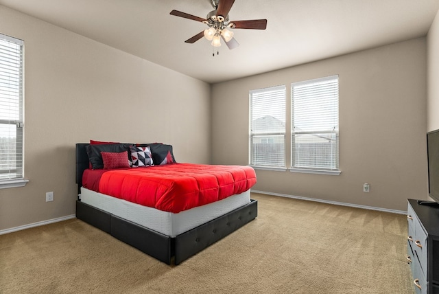 carpeted bedroom featuring multiple windows and ceiling fan