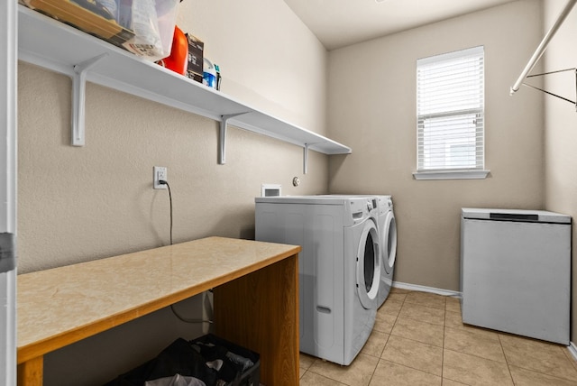 laundry area featuring washer and dryer and light tile patterned floors