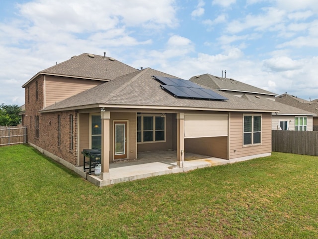 back of house featuring solar panels, a yard, and a patio area