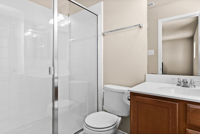 bathroom featuring toilet, vanity, and walk in shower