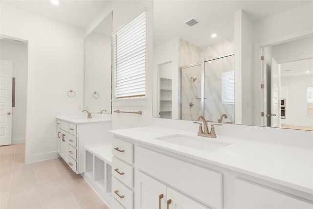 bathroom featuring a shower with door, vanity, and tile patterned flooring