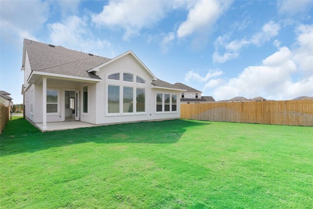 rear view of property featuring a yard and a patio