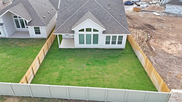 back of house with a patio and a lawn