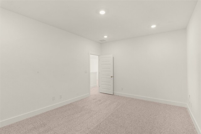 spare room featuring light colored carpet