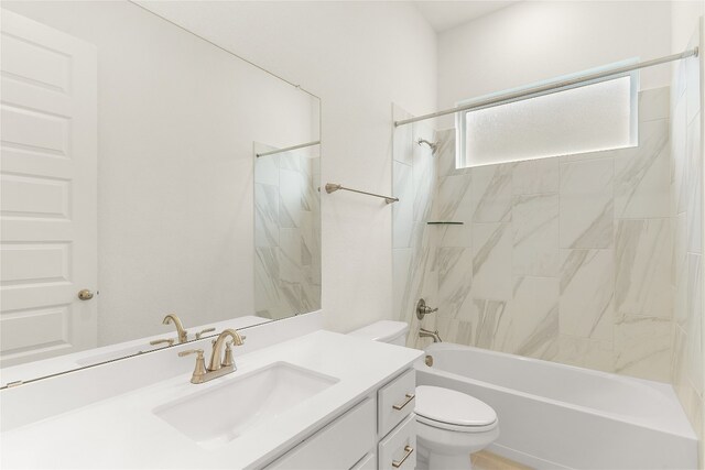 full bathroom with tiled shower / bath, vanity, and toilet