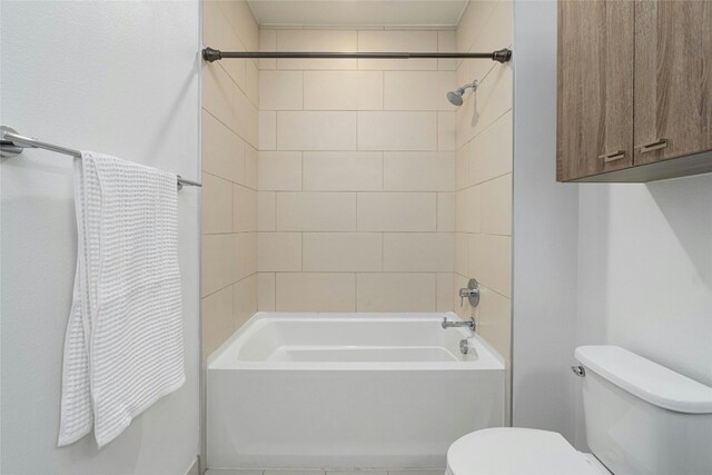 bathroom with toilet and tiled shower / bath