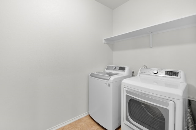 washroom featuring washer and dryer and light tile patterned flooring