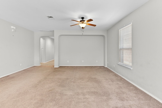 empty room with ceiling fan and light carpet