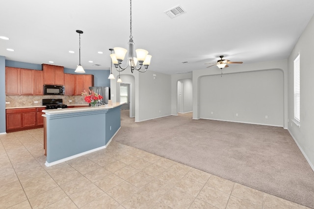 kitchen featuring ceiling fan with notable chandelier, light colored carpet, black appliances, pendant lighting, and decorative backsplash