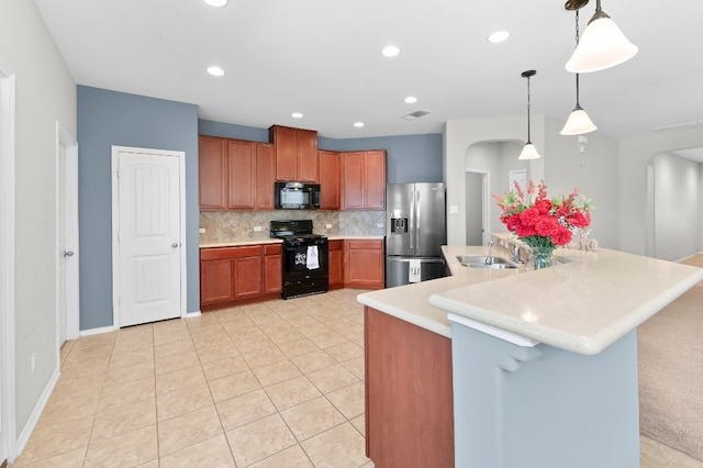 kitchen featuring backsplash, light tile patterned floors, hanging light fixtures, sink, and black appliances