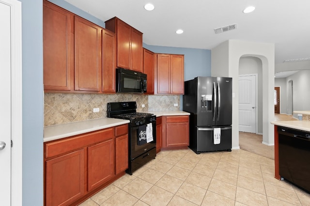 kitchen featuring black appliances, backsplash, and light tile patterned floors