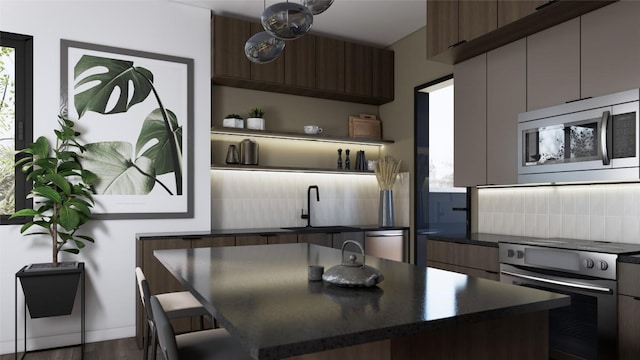 kitchen featuring backsplash, dark hardwood / wood-style flooring, a kitchen island, and stainless steel appliances