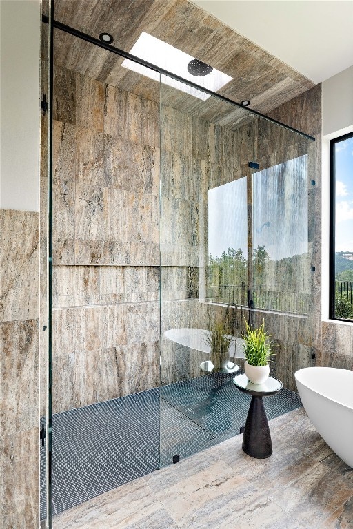 bathroom with tile walls and independent shower and bath