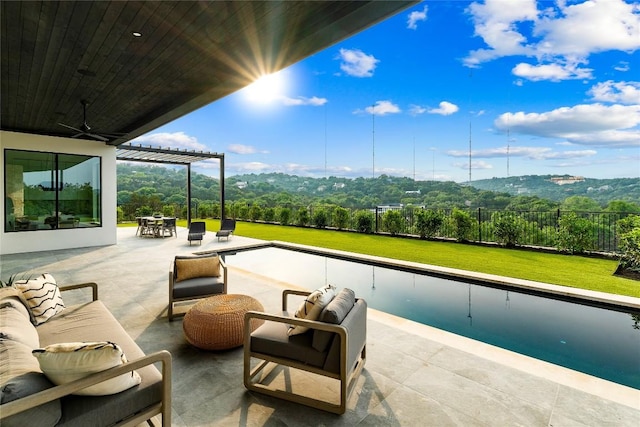 view of pool featuring outdoor lounge area, ceiling fan, a pergola, a mountain view, and a patio area