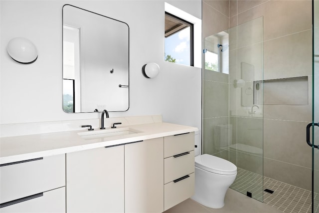 bathroom featuring vanity, a shower with shower door, and toilet