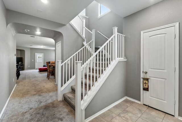 staircase featuring light colored carpet