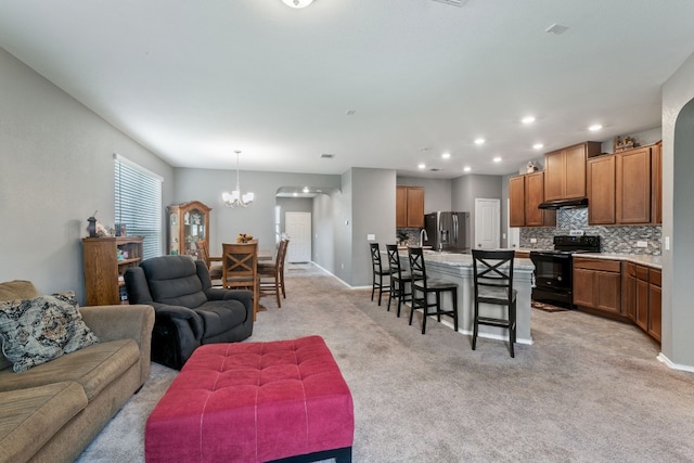 living room with light carpet, an inviting chandelier, baseboards, and recessed lighting