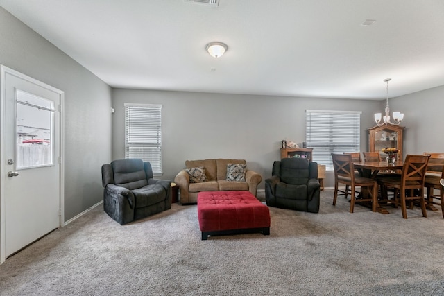 carpeted living area with a chandelier and a wealth of natural light