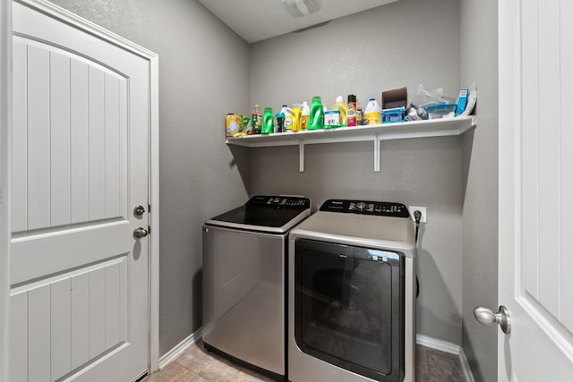 clothes washing area with laundry area, baseboards, and washing machine and clothes dryer