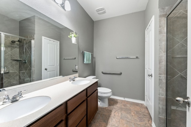 full bath featuring double vanity, a stall shower, a sink, and baseboards