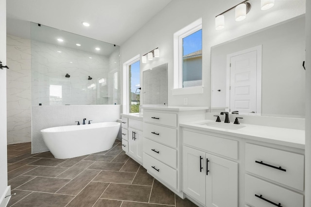 bathroom featuring a freestanding tub, recessed lighting, a walk in shower, and vanity