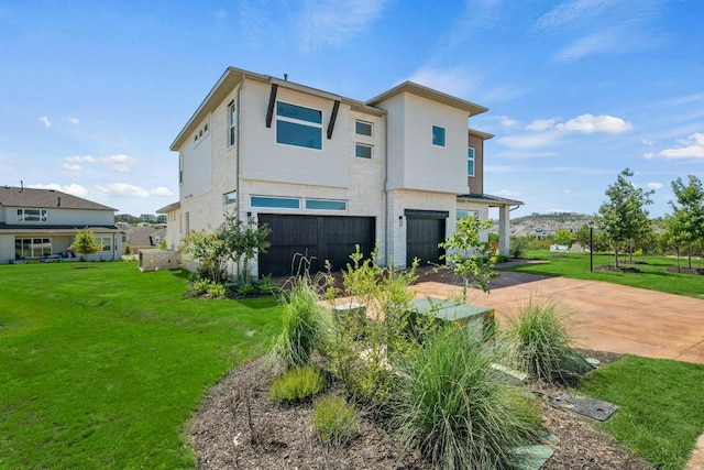 back of property featuring an attached garage, stucco siding, a lawn, and concrete driveway