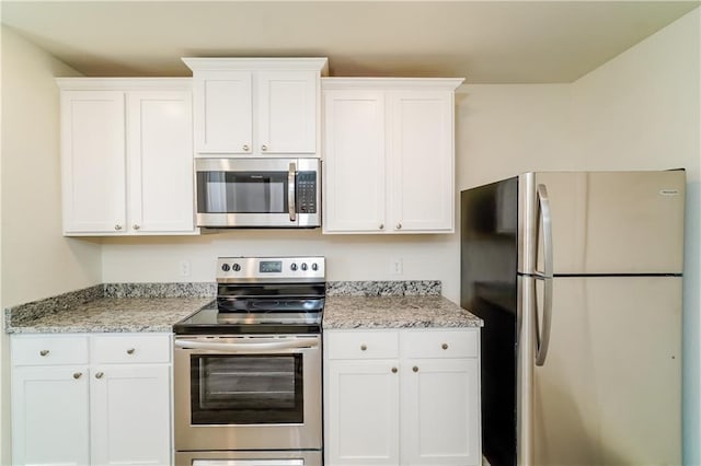 kitchen with white cabinets, stainless steel appliances, and light stone counters