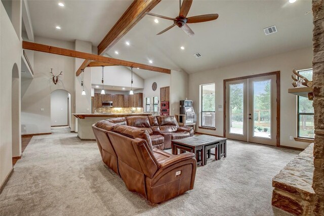 carpeted living room with ceiling fan, high vaulted ceiling, french doors, and beamed ceiling