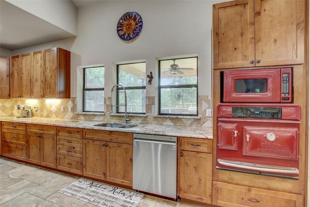 kitchen featuring sink, dishwasher, backsplash, light stone counters, and built in microwave