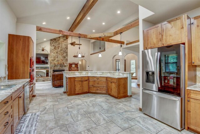 kitchen featuring sink, ceiling fan, appliances with stainless steel finishes, beam ceiling, and a fireplace