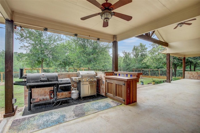 view of patio / terrace with an outdoor fireplace, ceiling fan, and an outdoor kitchen