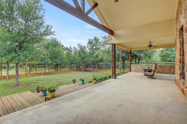 view of patio / terrace with a deck, ceiling fan, and an outdoor fire pit