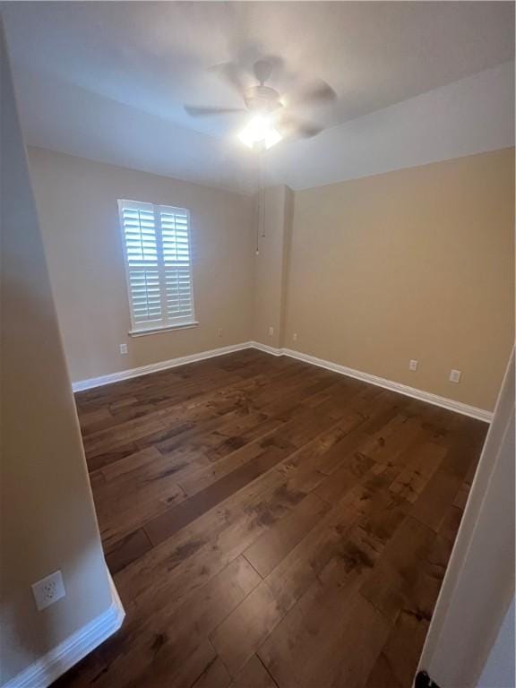 empty room with ceiling fan and dark hardwood / wood-style flooring