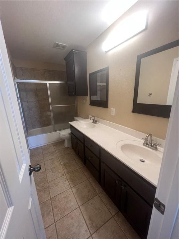 full bathroom featuring tile patterned flooring, vanity, toilet, and enclosed tub / shower combo