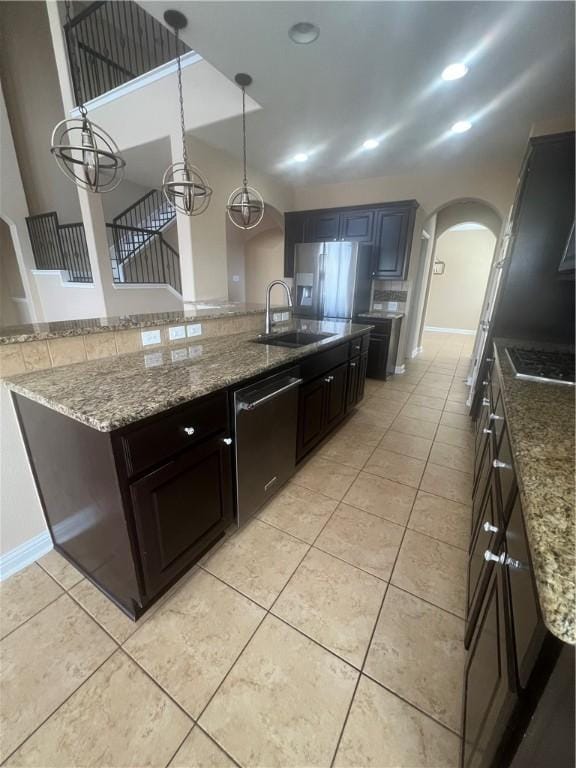 kitchen with appliances with stainless steel finishes, sink, an inviting chandelier, hanging light fixtures, and light tile patterned flooring