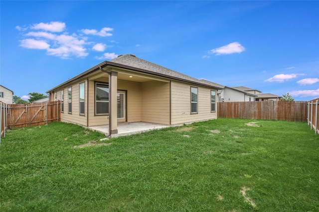 rear view of house with a patio and a lawn