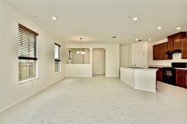 kitchen featuring a kitchen island with sink, an inviting chandelier, sink, hanging light fixtures, and electric range