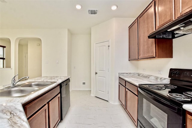 kitchen featuring light stone counters, sink, and black appliances