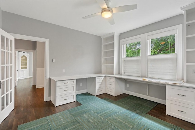 unfurnished office with built in desk and ceiling fan