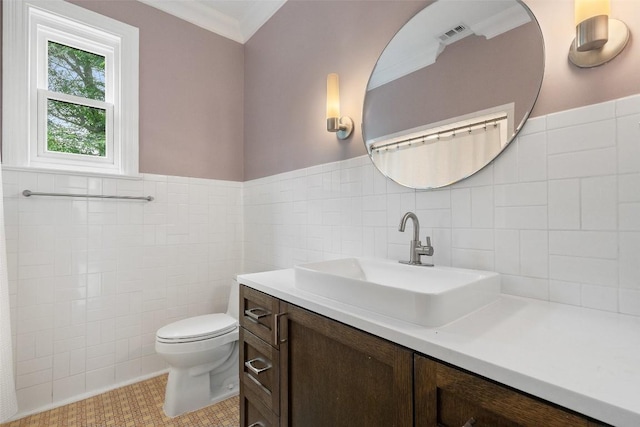 bathroom with tile patterned floors, crown molding, vanity, and tile walls