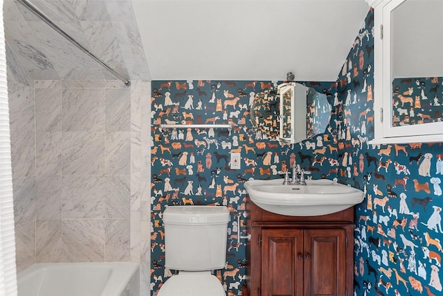 bathroom featuring a tub, vanity, and toilet