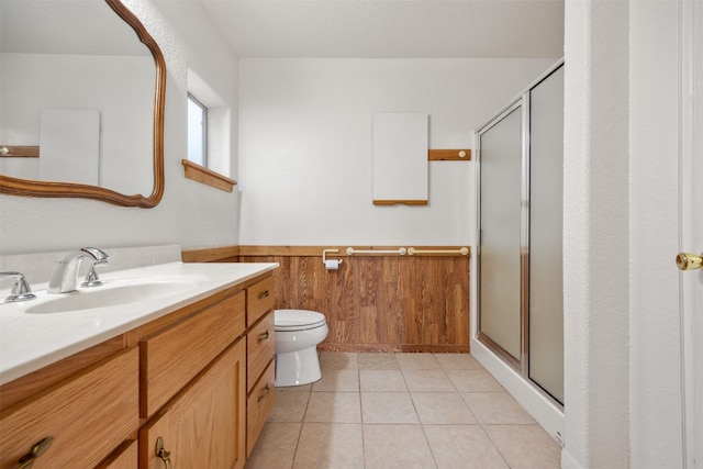 bathroom with tile patterned flooring, vanity, an enclosed shower, and wooden walls