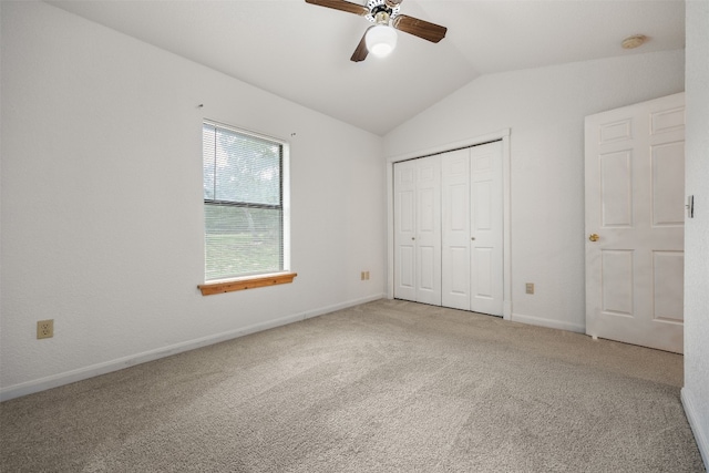 unfurnished bedroom featuring ceiling fan, a closet, carpet floors, and lofted ceiling